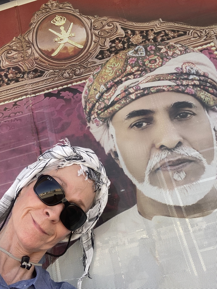 Selfie avec une grande image d'un homme en turban.
