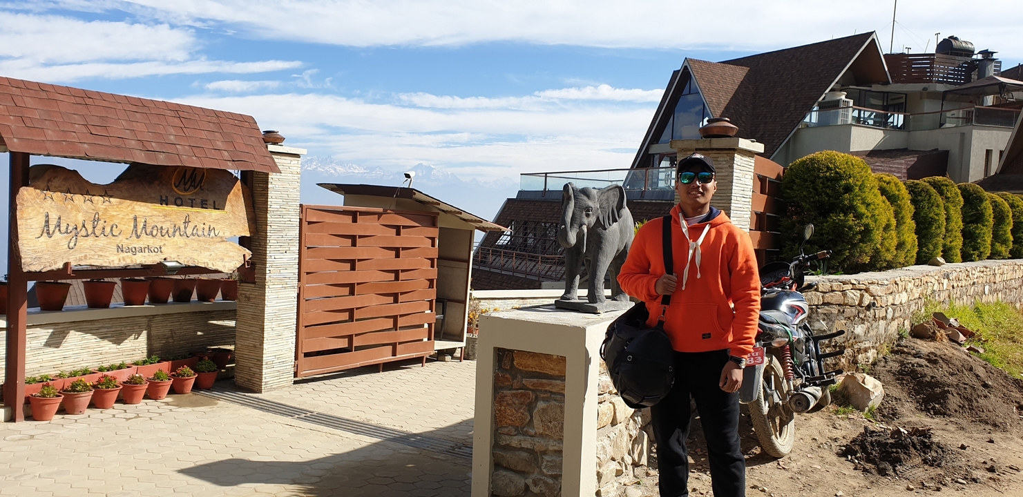 Personne posant à côté d'une statue d'éléphant.