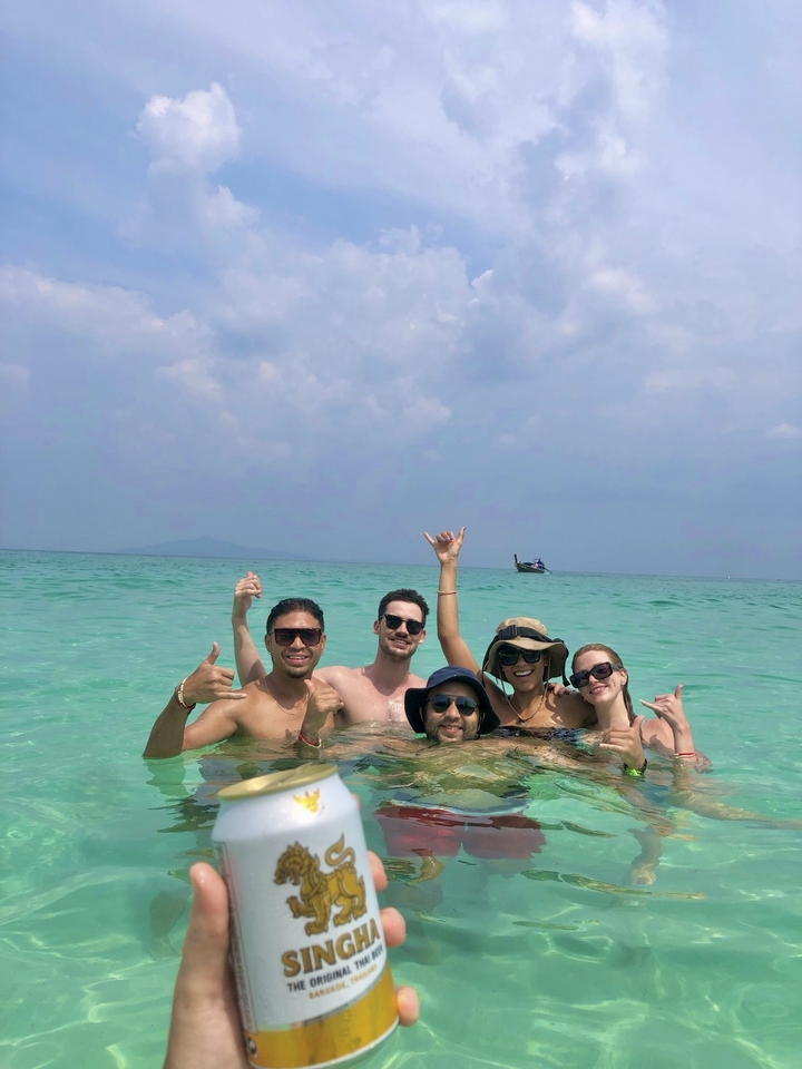 Group of people swimming in ocean with a distant boat.