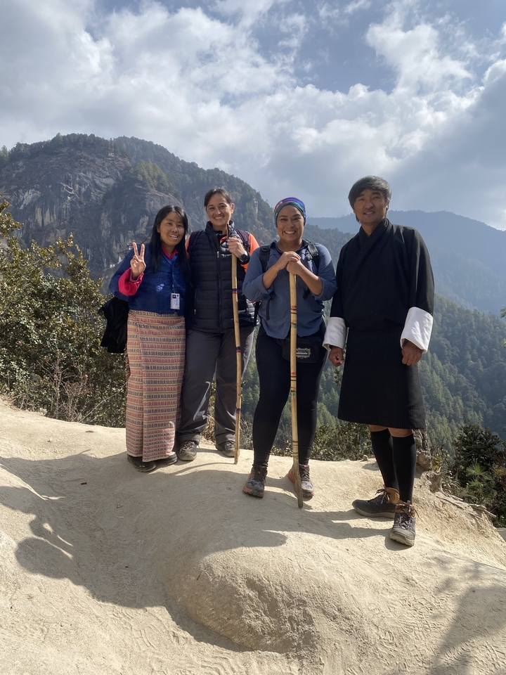 Groupe de personnes posant pour une photo avec un paysage de montagne.