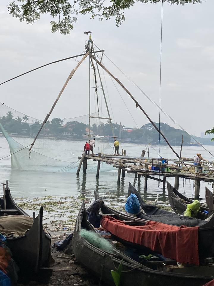 Technique de pêche traditionnelle avec de grands filets, des personnes en arrière-plan.