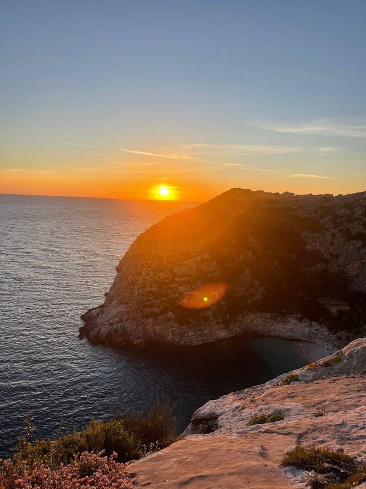 Coucher de soleil éclatant sur la mer et les falaises.