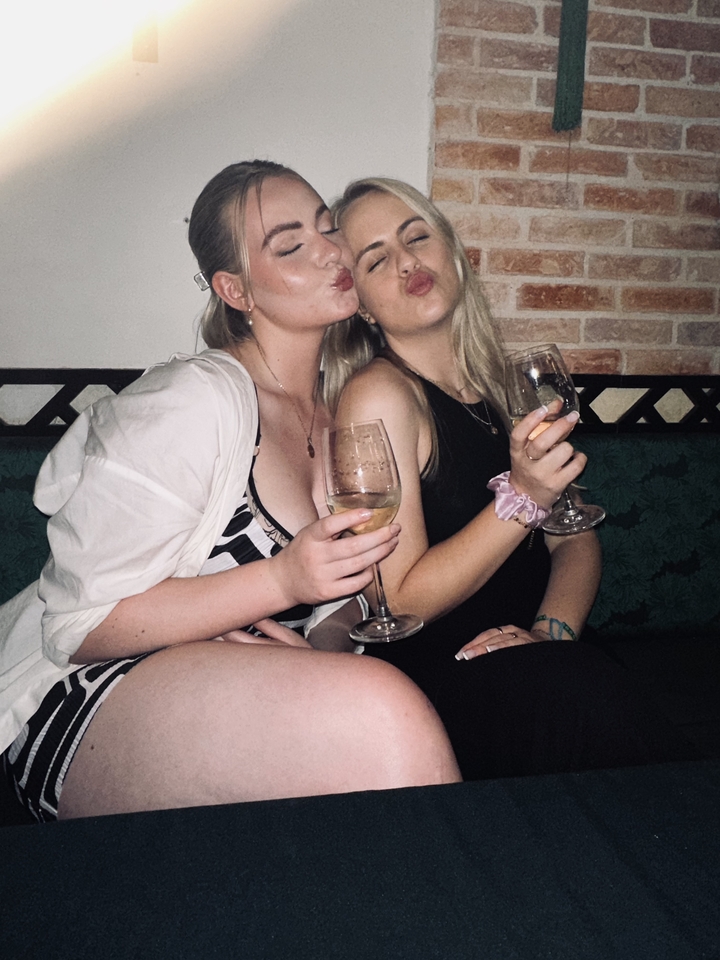 Deux femmes assises qui savourent des boissons à l'intérieur.