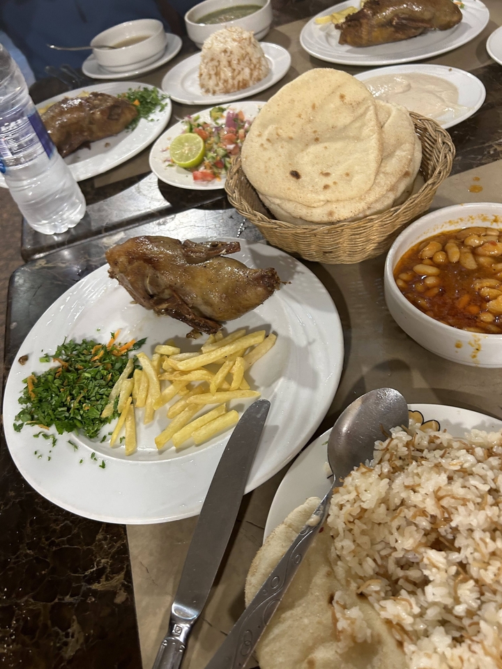 Repas traditionnel avec des haricots, des frites et du poulet rôti.