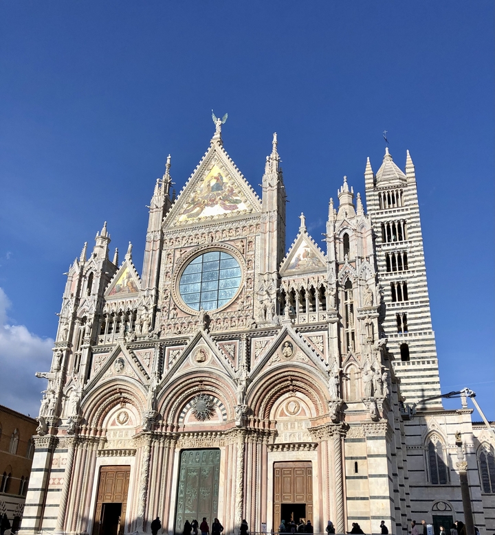 Façade complexe de cathédrale de style gothique contre un ciel bleu clair.