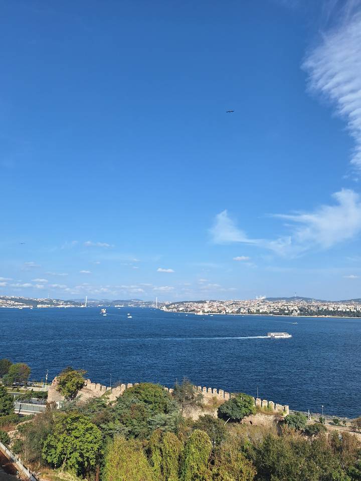 Vue sur l'eau avec des bateaux et une ville en arrière-plan.