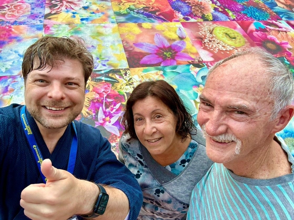 Selfie de groupe avec un arrière-plan floral coloré.