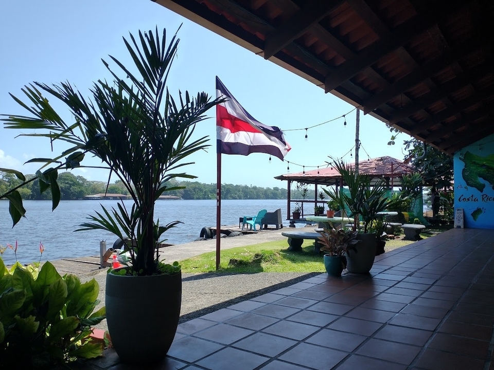 Zone de places assises extérieure au bord d'une rivière avec drapeau national.