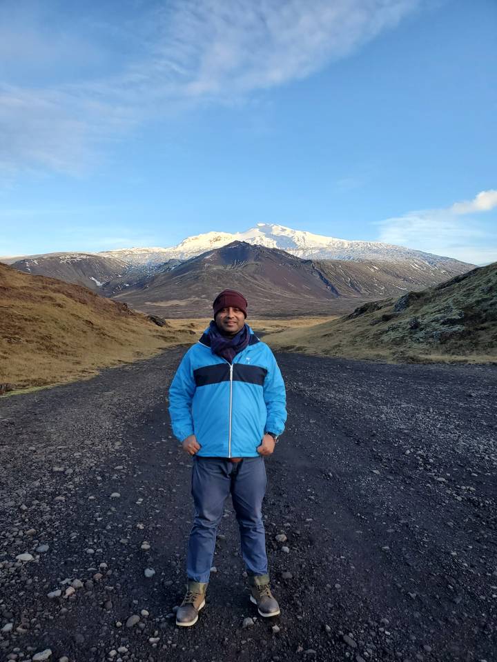 Traveler in a mountainous area with snow peaks in the distance.