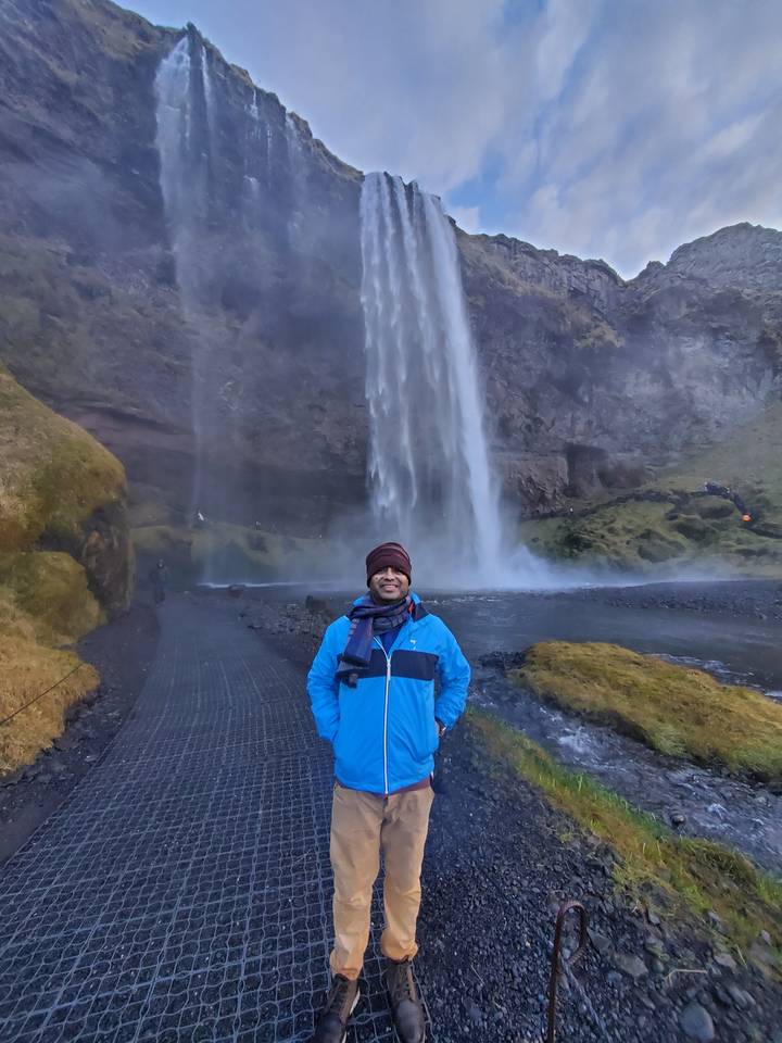 Traveler enjoying the view of a large waterfall.