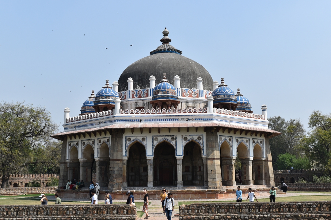 Bâtiment historique au dôme blanc entouré de personnes.