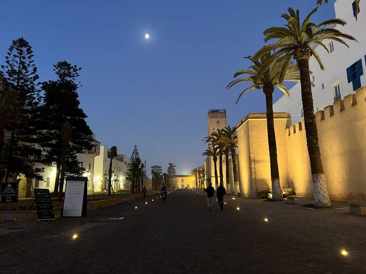 A wider view of an illuminated street in Essaouira at dusk.
