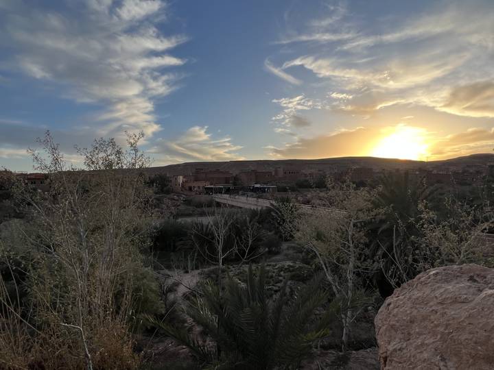 A serene sunset view over a desert landscape with buildings.