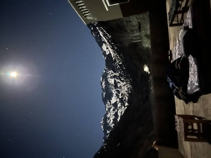 A snowy mountain view under a starry night sky.