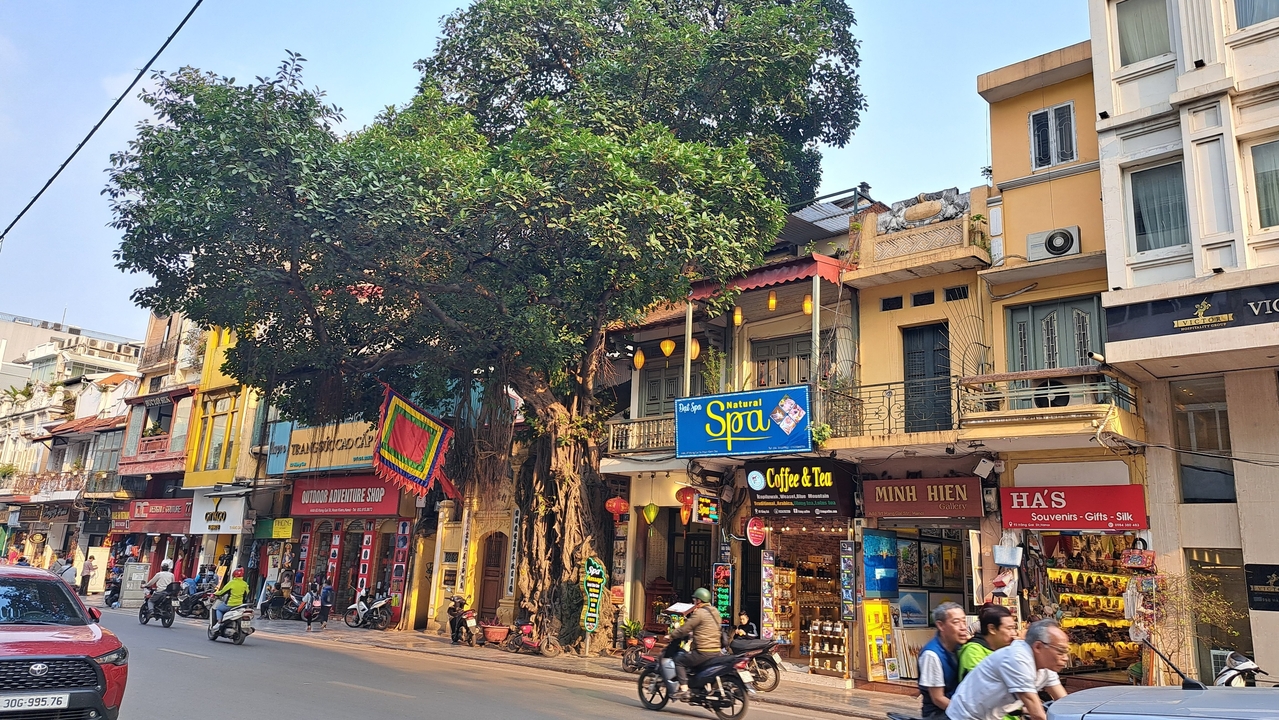 Rue commerçante animée avec des enseignes de marché colorées.
