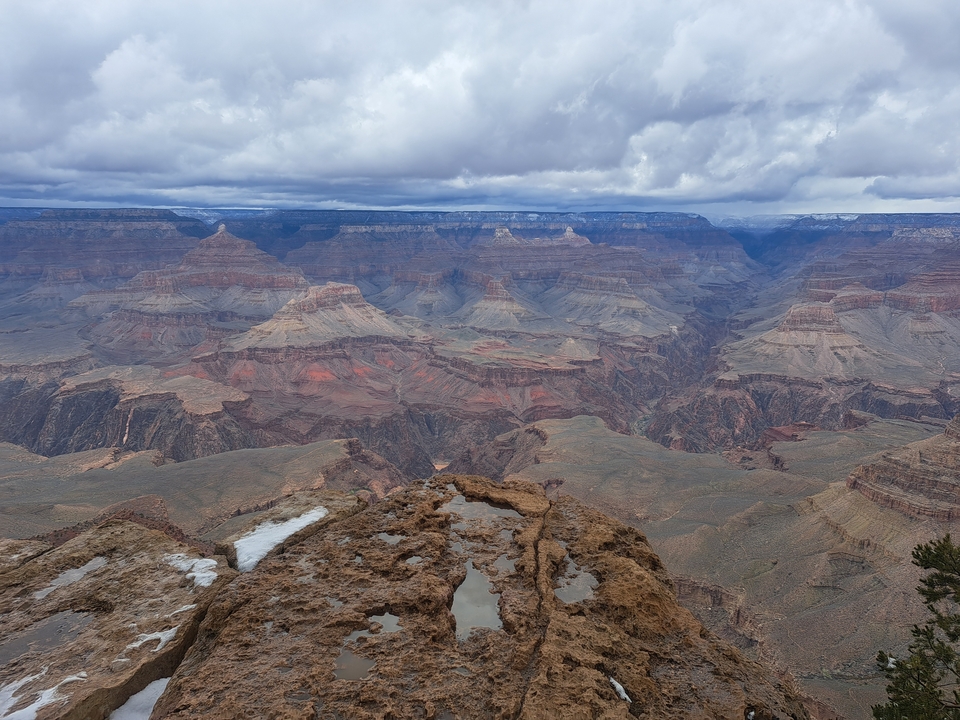 Vue panoramique du Grand Canyon avec un ciel nuageux.