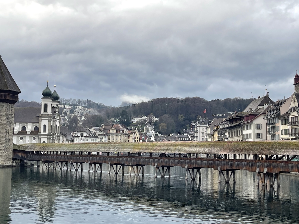 Pont historique enjambant une rivière avec en arrière-plan une architecture européenne traditionnelle.