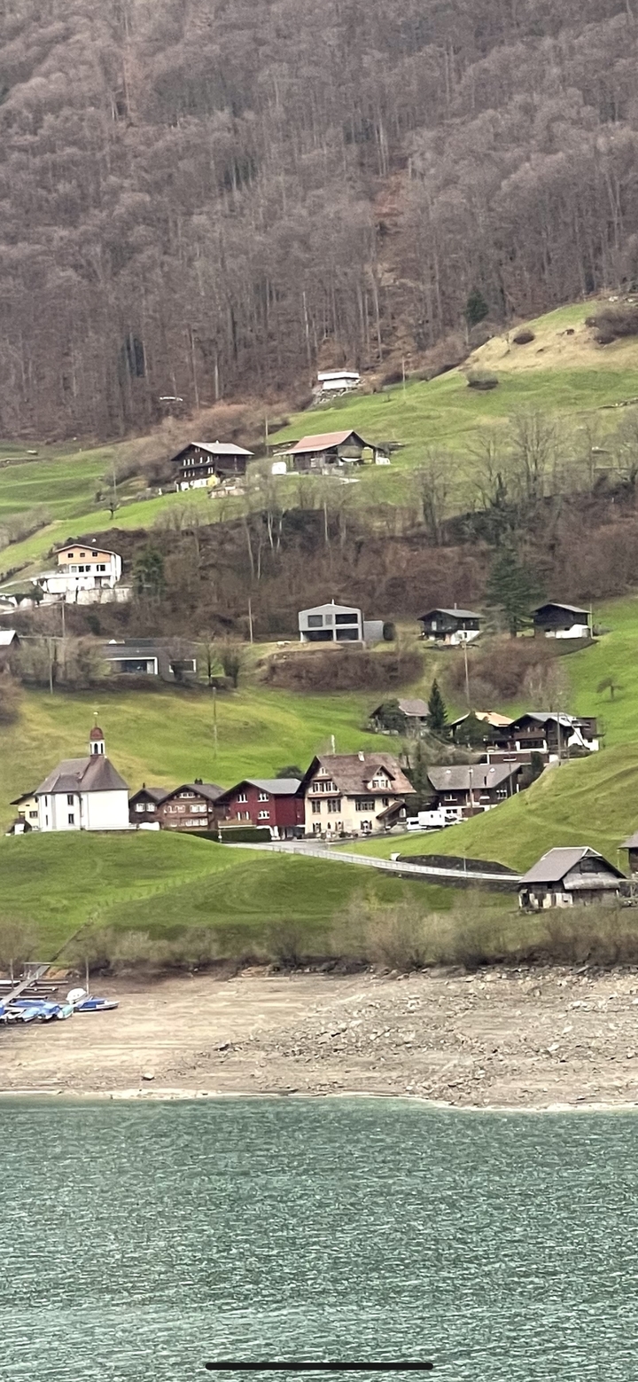 Vue panoramique d'une colline avec des bâtiments traditionnels et une église.
