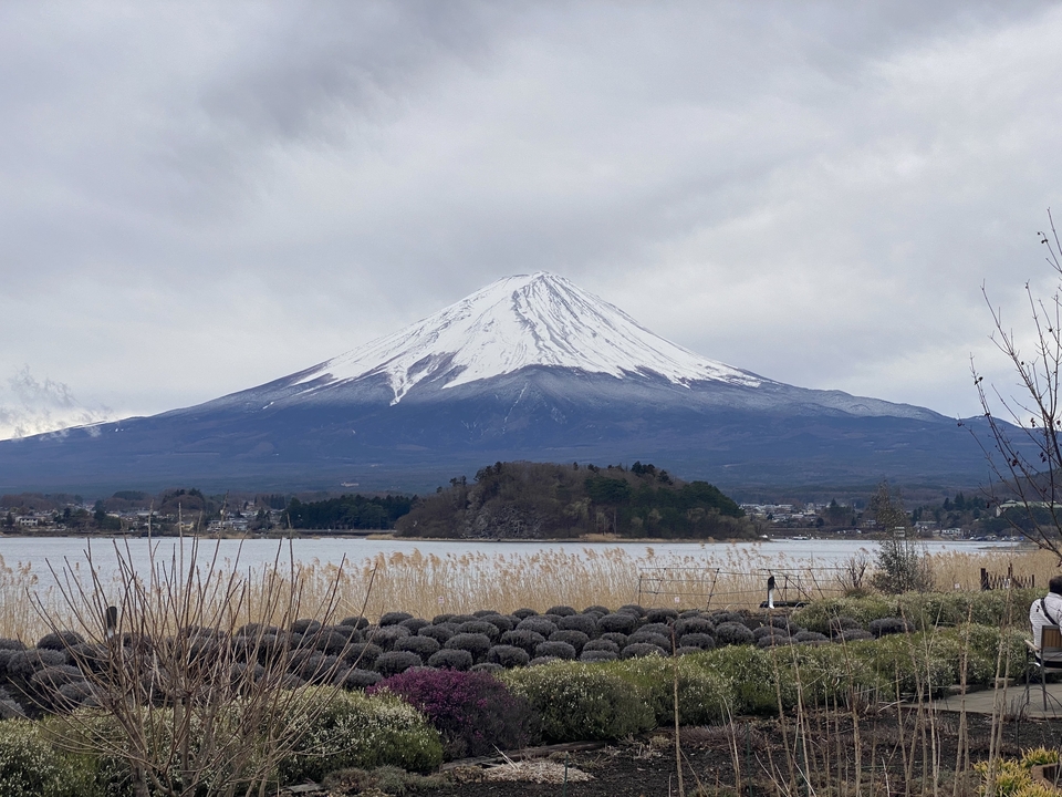Beautiful view of snow-capped Mount Fuji with a lake and foreground landscape.