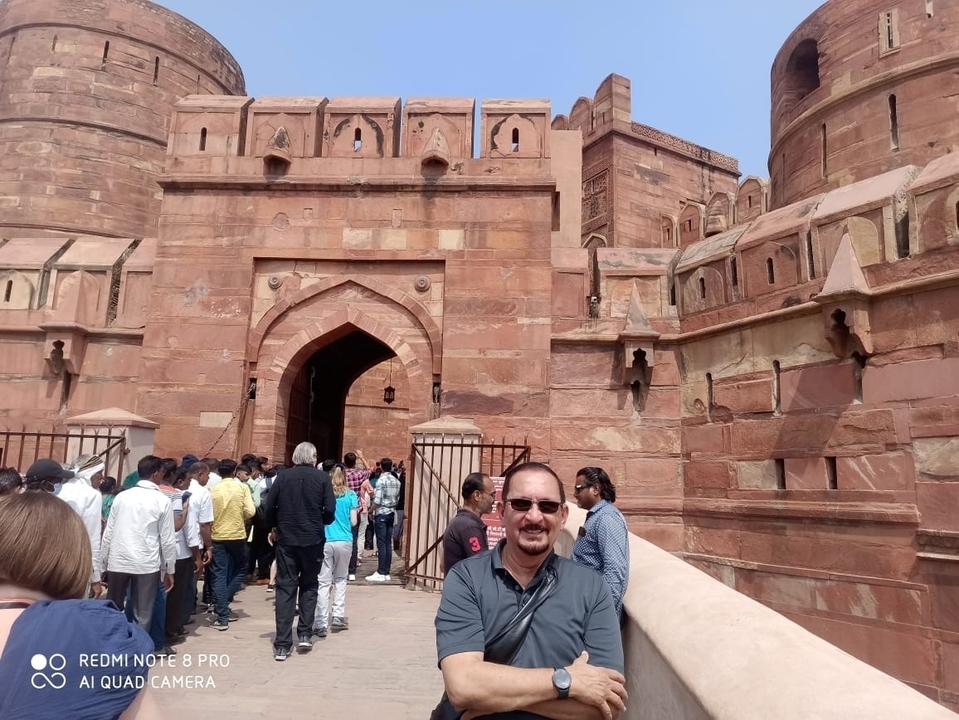 Des gens qui font la queue devant un fort rouge historique.