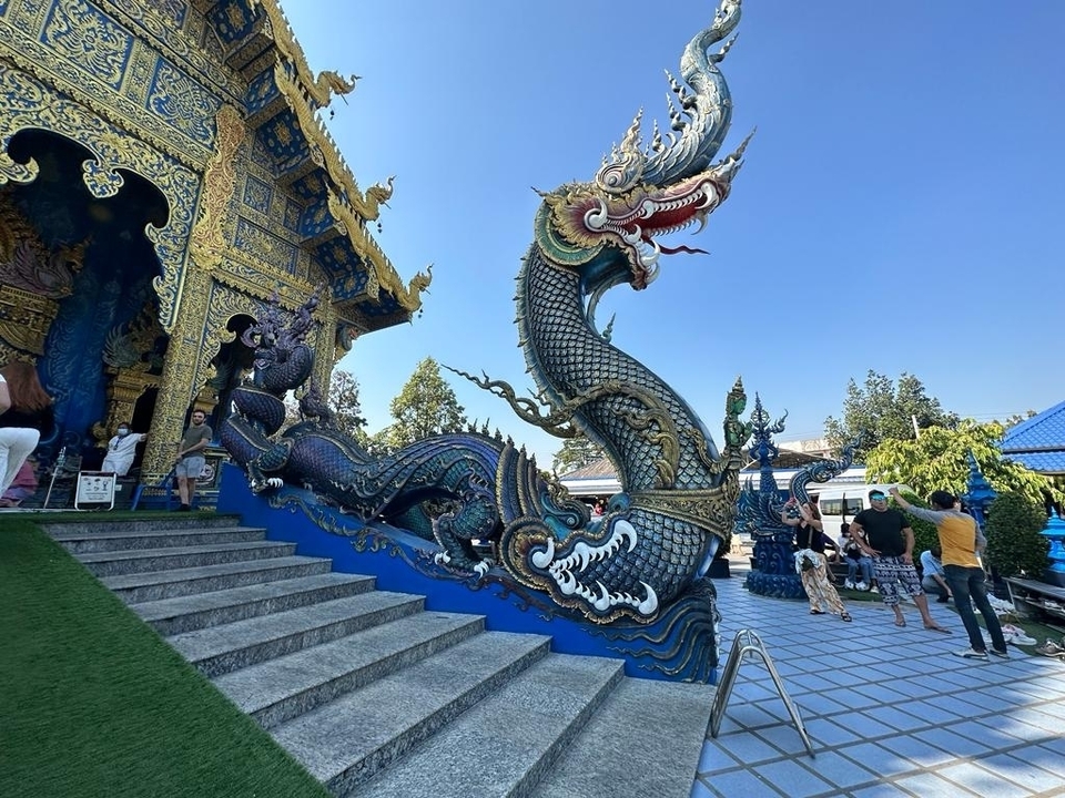 Temple avec des sculptures de dragons complexes et des gens en visite.