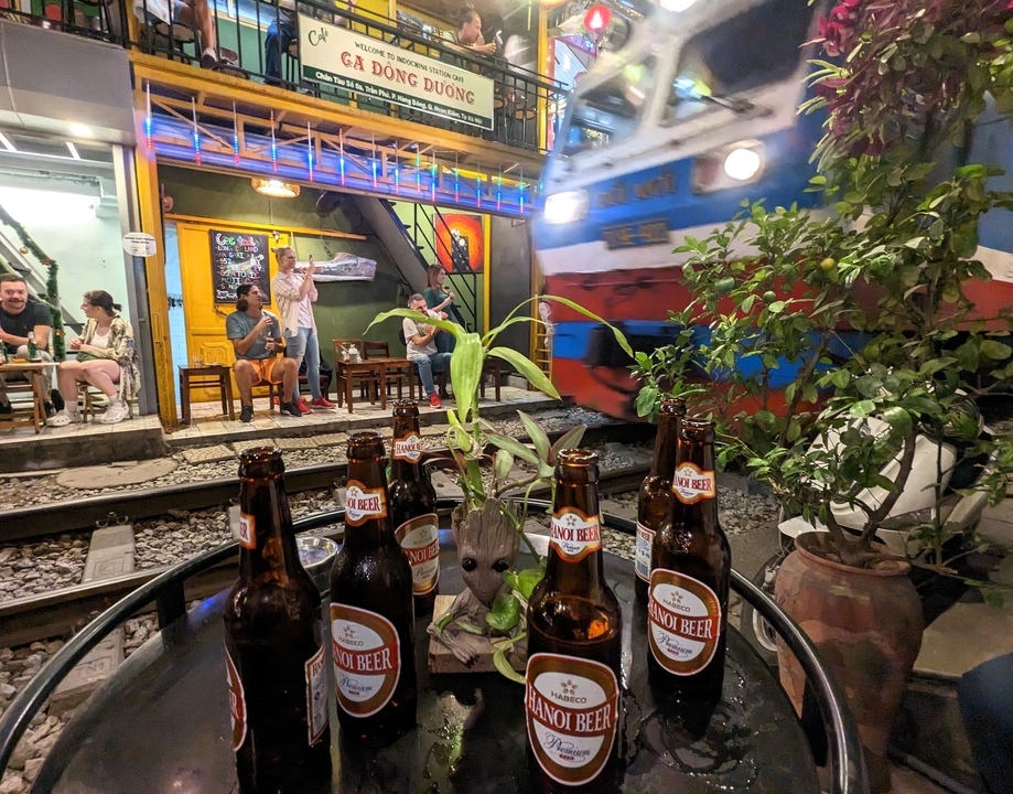 Des gens qui profitent de boissons près d'une voie ferrée.