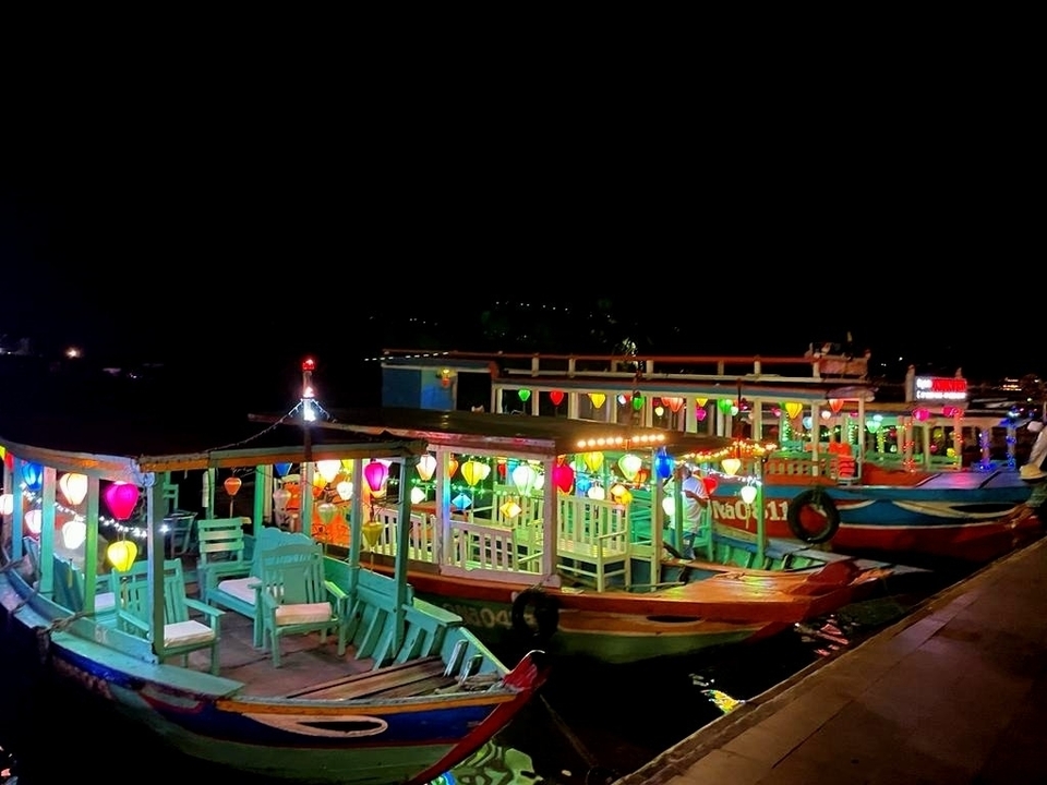 Bateaux colorés illuminés la nuit.