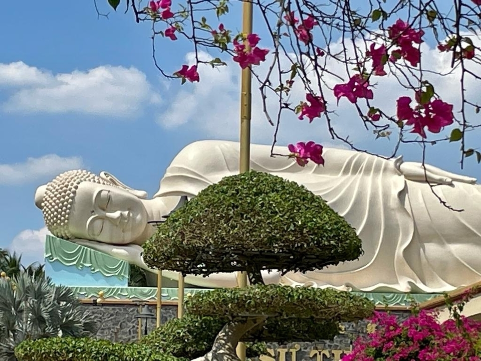 Statue de Bouddha couché avec des fleurs de cerisier.