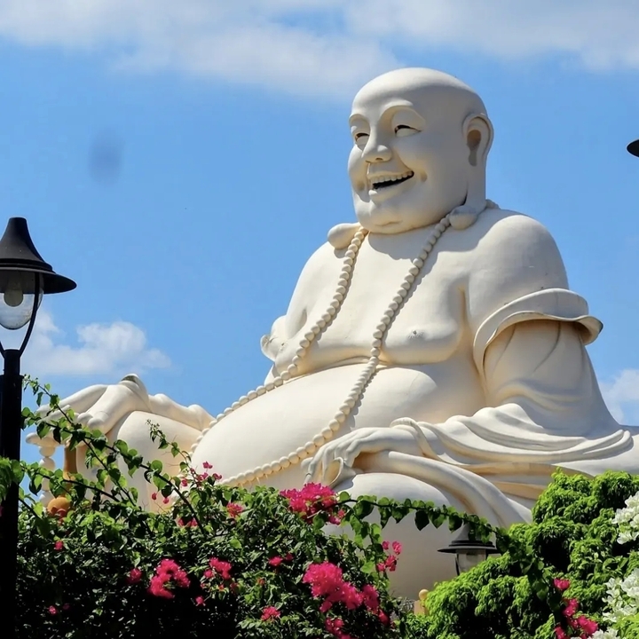Gros plan d'une statue de Bouddha et de fleurs.