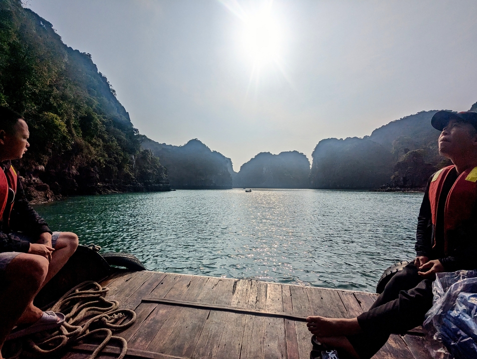 Des gens sur un bateau avec une vue sur la baie d'Halong.