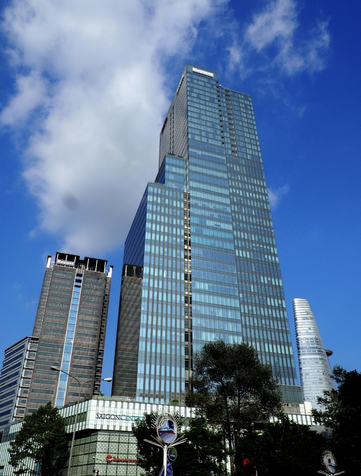 Gratte-ciel moderne avec façade de verre contre le ciel bleu.