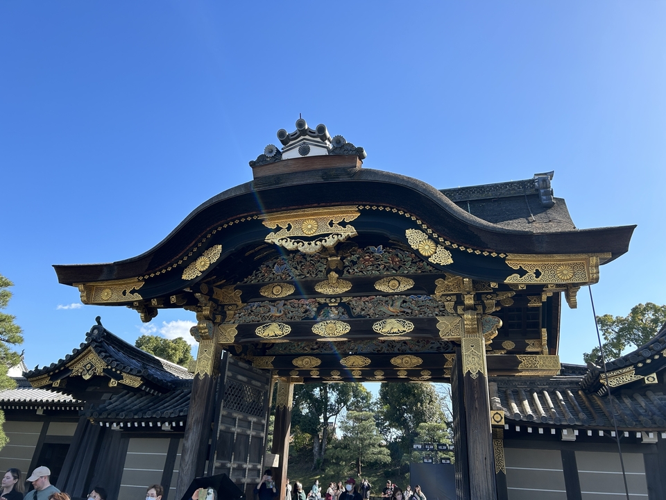 Portail orné avec des décorations dorées sur fond de ciel bleu.