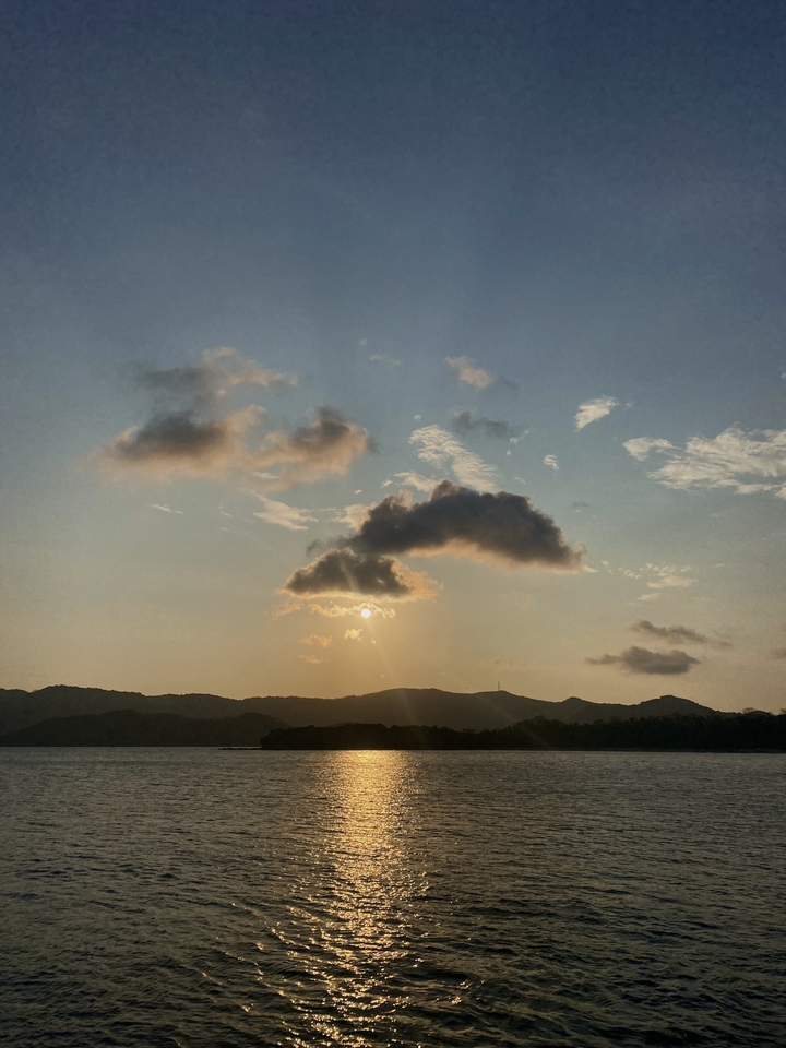 A scenic view of sunset with mountains and clouds.