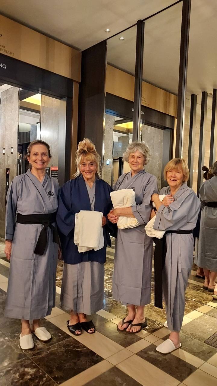 Quatre femmes en robes traditionnelles qui sourient.