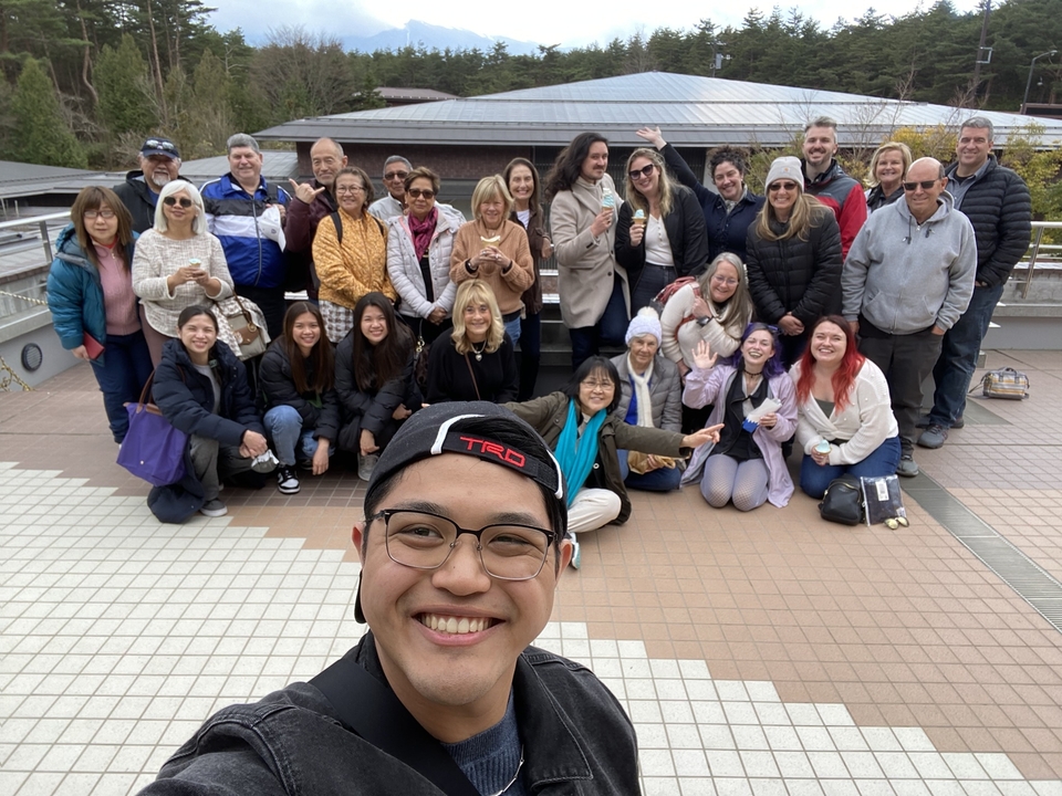 Un grand groupe de voyageurs prenant la pose pour une photo sur un toit.