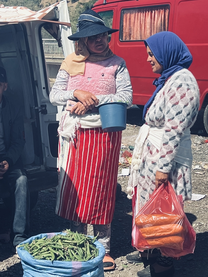 Deux personnes en vêtements traditionnels tenant des objets.