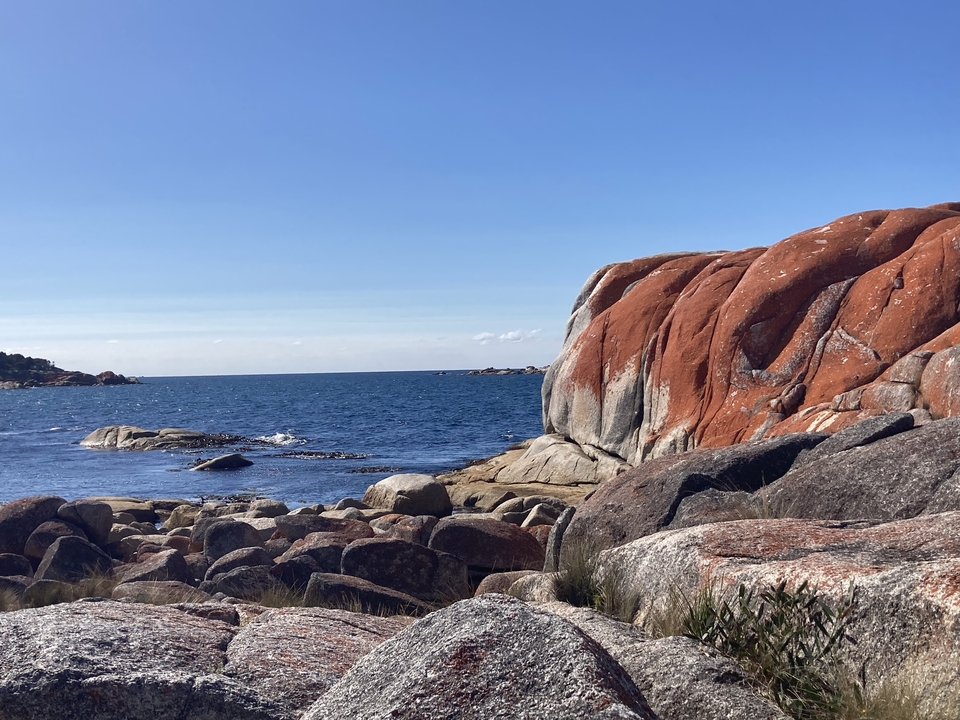 Formations rocheuses au bord de la mer avec un ciel dégagé.