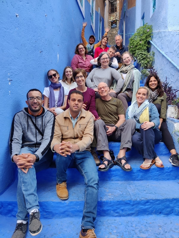 Groupe de personnes assises sur des escaliers bleus.
