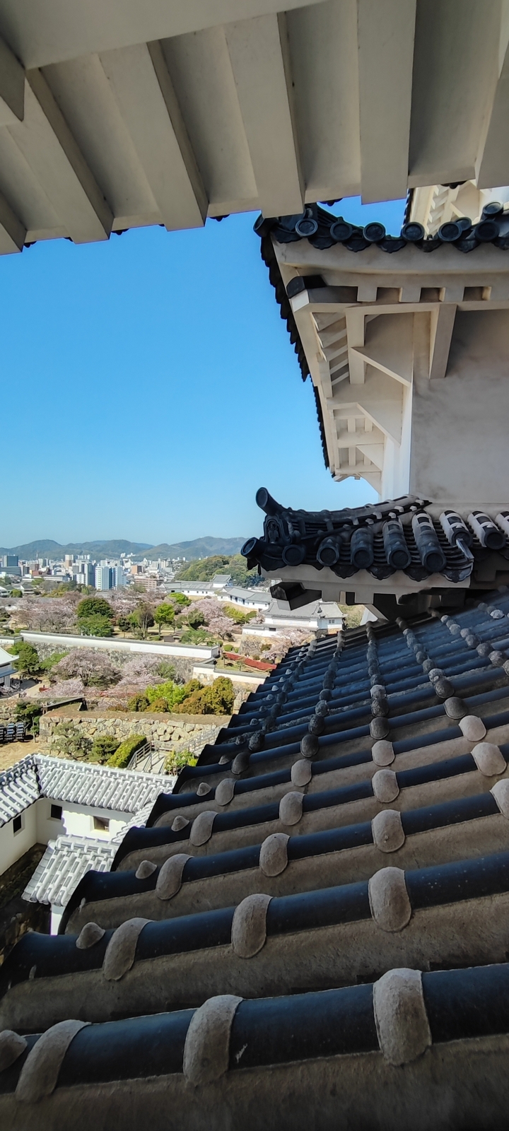 Un toit japonais traditionnel avec une vue sur la ville en arrière-plan.