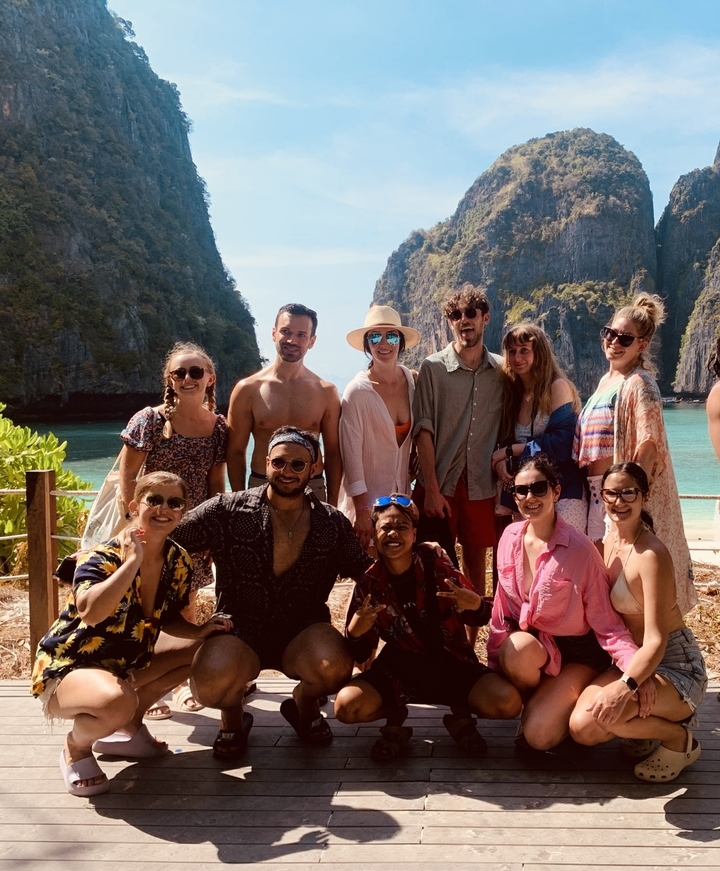 Group photo with people posing in front of a scenic bay.