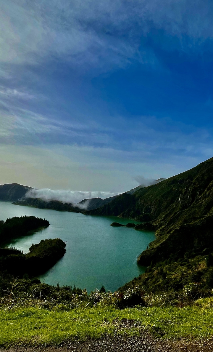 Paysage montagneux avec un lac sous un ciel dégagé.