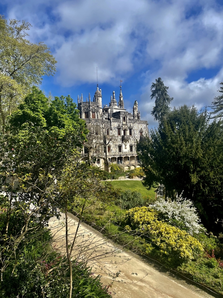 Un bâtiment majestueux entouré d'arbres et de jardins.