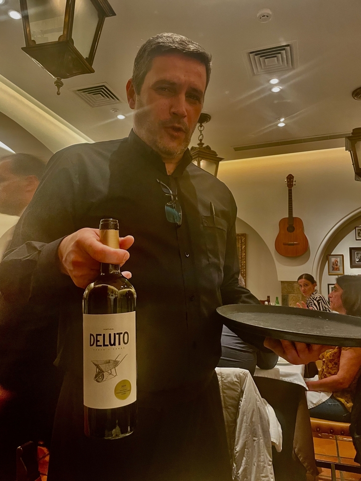 Un serveur tenant une bouteille de vin dans un restaurant.