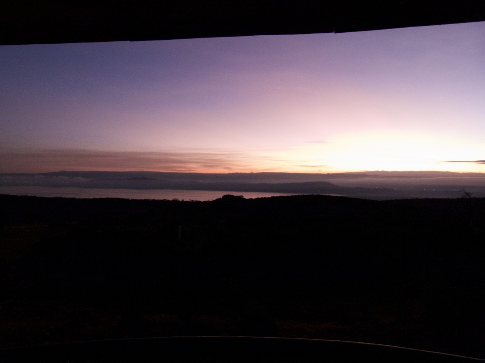 Sunset over a lake with a silhouette of hills.