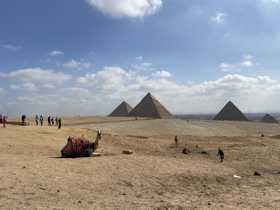 Pyramids with camels and people in the foreground
