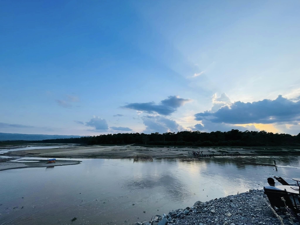 River flowing through a landscape with a sunset sky.