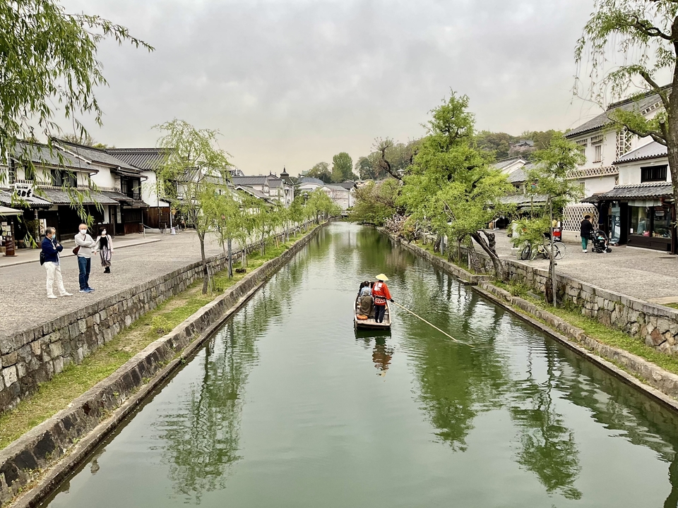 Un canal qui traverse une ville japonaise historique avec des gens sur un bateau.