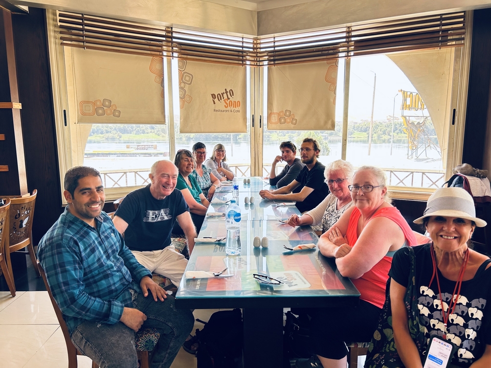 Groupe de personnes assises à une grande table dans un restaurant.