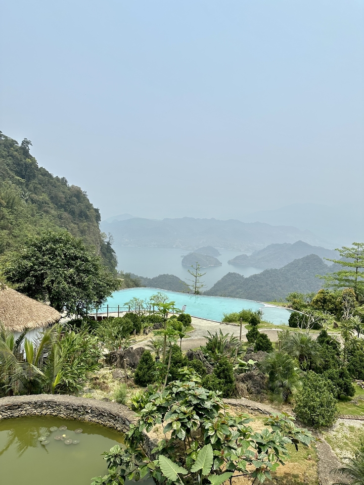Vue panoramique d'un lac entouré de montagnes luxuriantes.