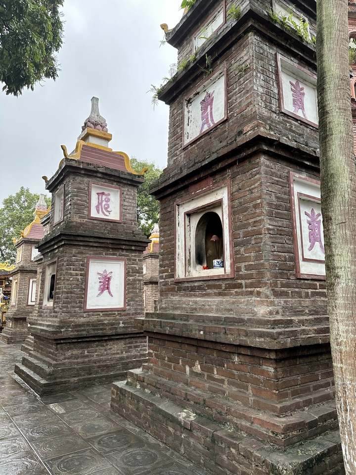 Gros plan de structures en briques anciennes avec des fenêtres ornées.